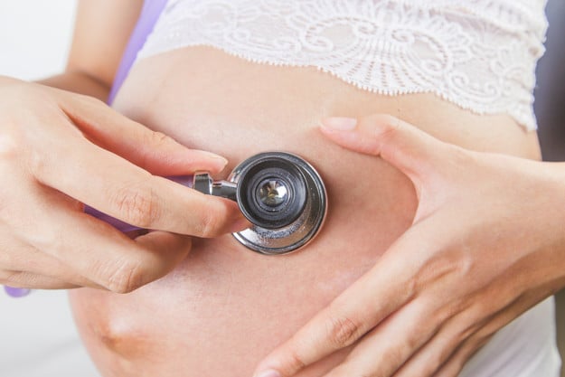 pregnant woman using stethoscope examining her baby her belly 1205 2225